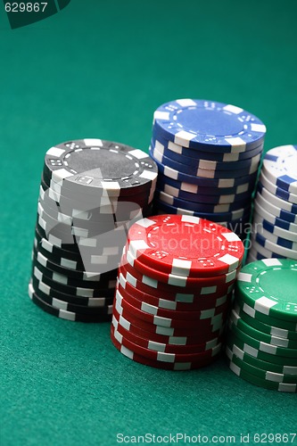 Image of Stacks of poker chips on a green surface.