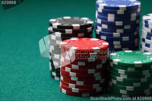 Image of Stacks of poker chips on a green surface.