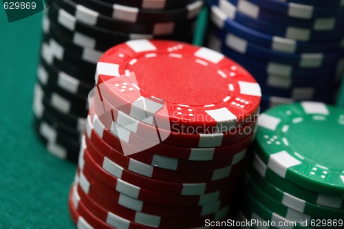 Image of Stacks of poker chips on a green surface.