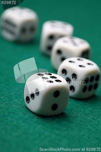 Image of Gambling die on a green surface.