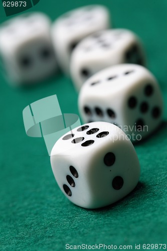 Image of Gambling die on a green surface.