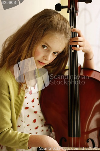 Image of Close-up portrait of a pretty young girl with a cello.
