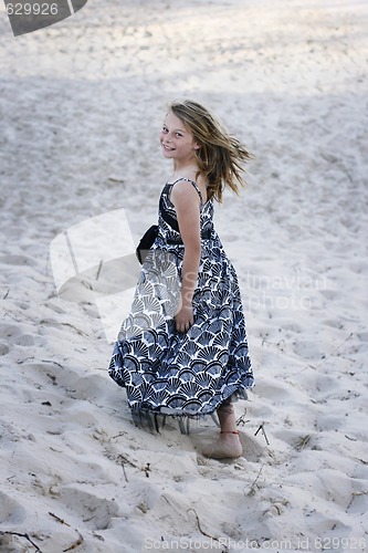 Image of Pretty teenager walking on the beach.