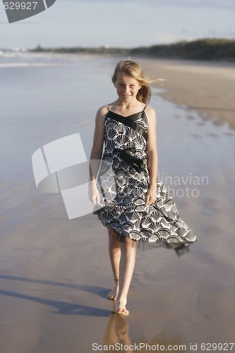 Image of Pretty teenager walking on the beach.