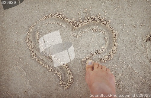 Image of Drawing a heart shape in the sand.