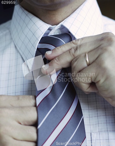 Image of Business man adjusting his tie.