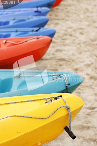 Image of Colorful kayaks on the sand.