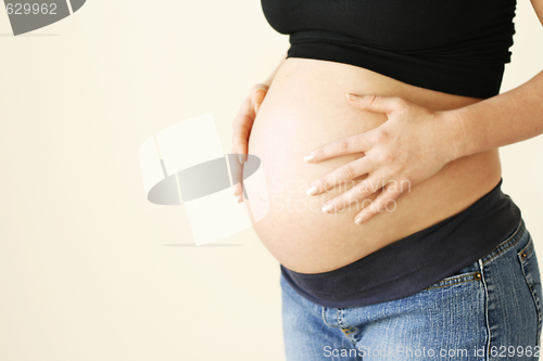 Image of Woman holding her pregnant belly.