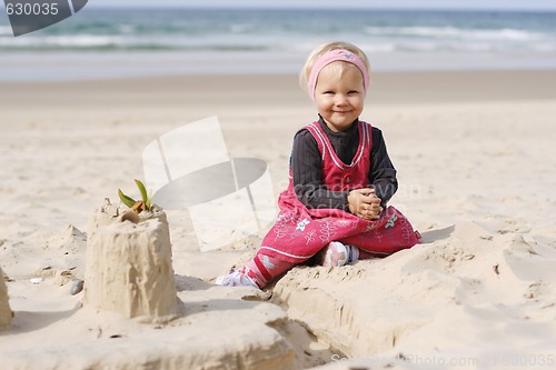 Image of Smiling little girl playing on the beach. 