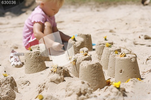 Image of A little girl making sand castles. 