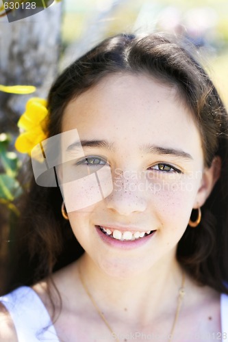 Image of Close-up portrait of a pretty, dark haired young girl outdoors.