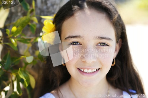 Image of Close-up portrait of a pretty, dark haired young girl outdoors.