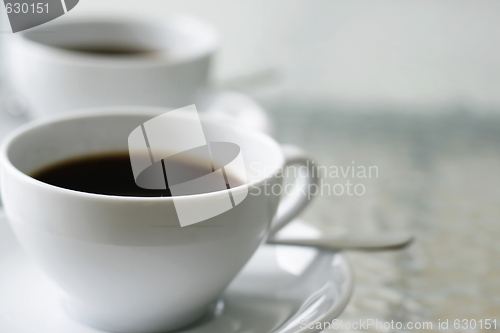 Image of Two black filter coffees in white cups.