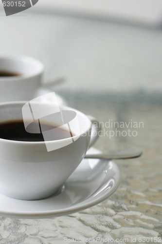 Image of Two black filter coffees in white cups.