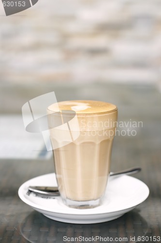 Image of Latte in a glass on a café table.