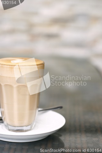Image of Latte in a glass on a café table.