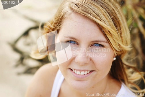 Image of Portrait of a happy beautiful young blonde woman at the beach.