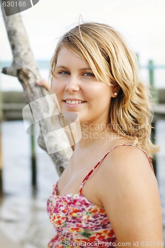 Image of Portrait of a happy beautiful young blonde woman at the beach.