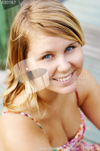 Image of Portrait of a smiling beautiful young blonde woman outdoors.