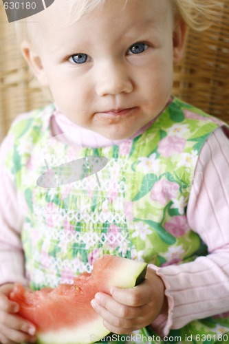 Image of Cute little girl eating a watermelon.