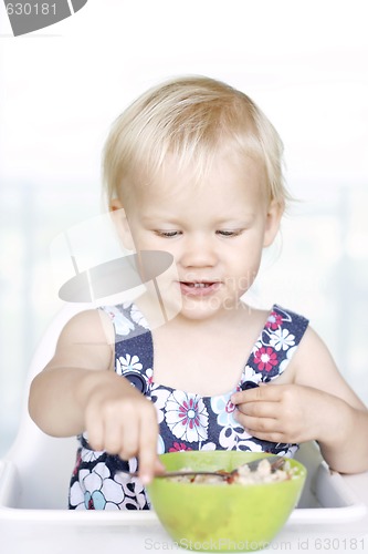 Image of Cute little girl and her breakfast porridge bowl.