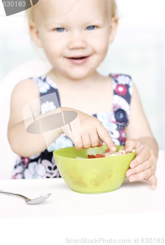 Image of Cute little girl and her breakfast porridge bowl.