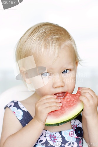 Image of Cute little girl eating a watermelon.