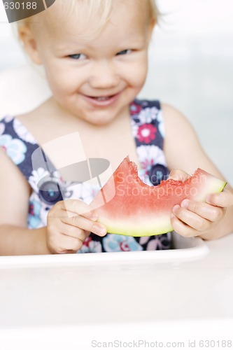 Image of Cute little girl eating a watermelon.