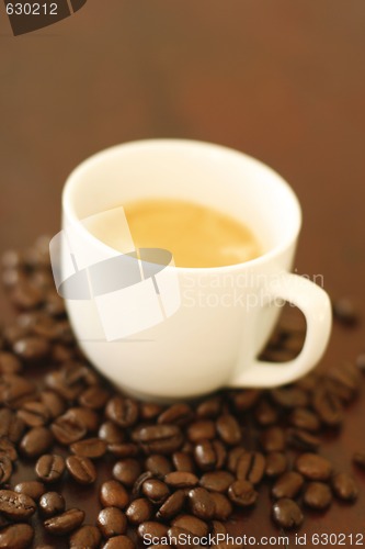 Image of Espresso in cup surrounded by coffee beans.