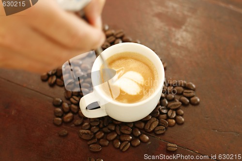 Image of Barista creating a heart shaped coffee art design.