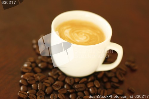 Image of Espresso in cup surrounded by coffee beans.