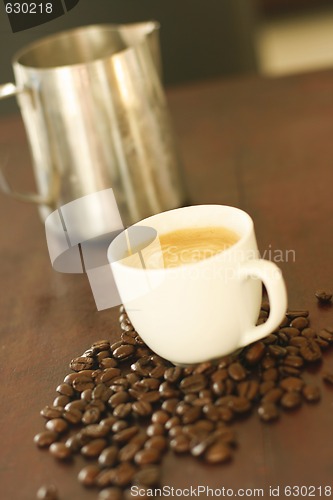 Image of Espresso in cup surrounded by coffee beans.