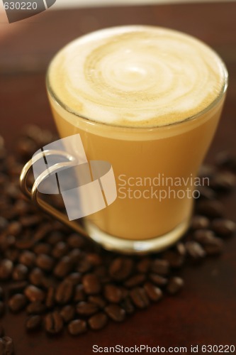 Image of Delicious latte in glass with coffee art swirl design.