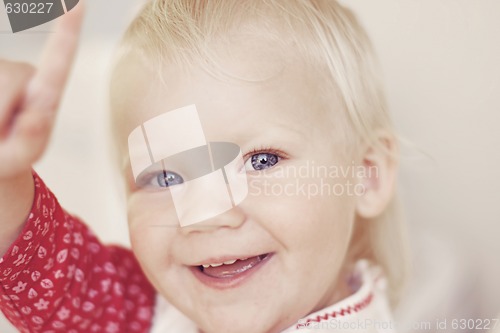 Image of Portrait of a smiling and laughing toddler pointing.