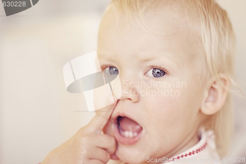Image of Cute little girl pointing at her nose.
