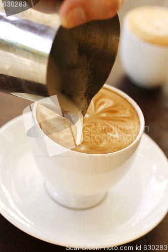 Image of A barista creating latte coffee art.
