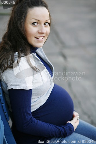 Image of Happy young pregnant woman outdoors.