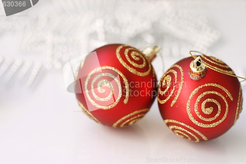 Image of Red Christmas baubles on a glass table.