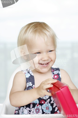 Image of Little girl gleefully opening Christmas gifts.