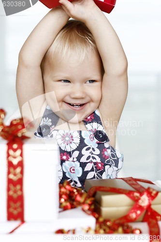 Image of Little girl gleefully opening Christmas gifts.