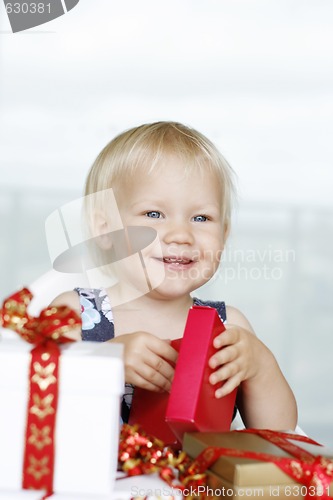 Image of Little girl gleefully opening Christmas gifts.