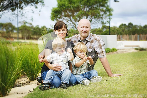 Image of Portrait of a happy family outdoors in a park.