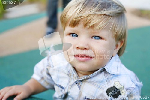 Image of A happy little boy at a play park looking at the camera.