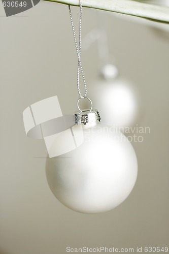 Image of Two white decorative Christmas baubles.