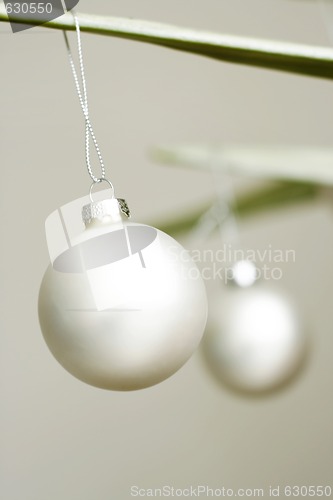 Image of Two white decorative Christmas baubles.