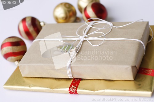 Image of Two simply wrapped Christmas gifts with decorations.