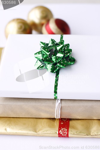 Image of Three simply wrapped Christmas gifts with decorations.