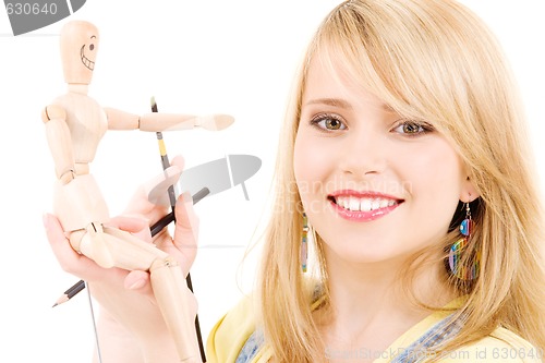 Image of happy teenage girl with wooden model dummy