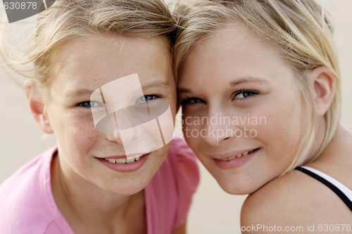 Image of Two happy young sisters together outdoors.