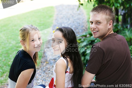 Image of Portrait of three happy adolescents together outdoors.